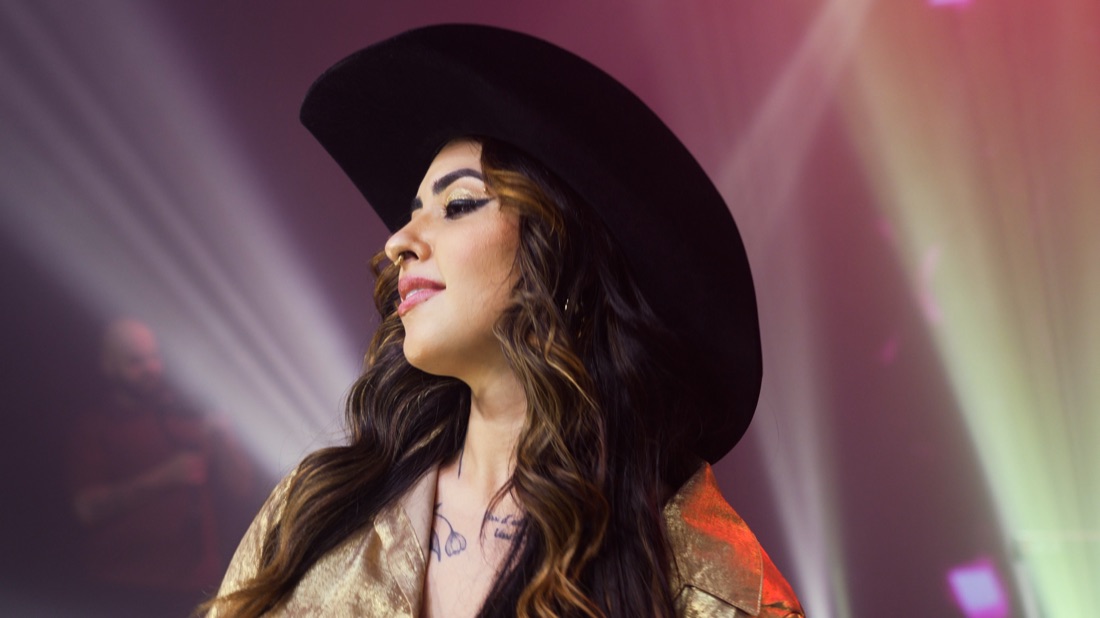 Vocalista da Banda Prime de perfil sob luzes magenta