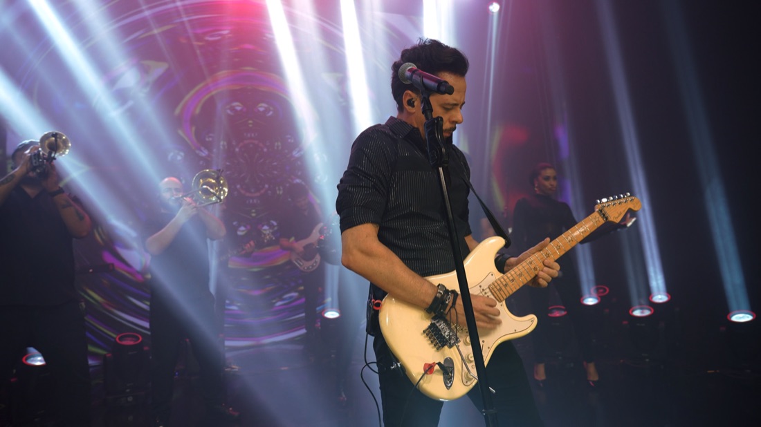 Guitarrista da Banda Prime em solo sob feixes de luz
